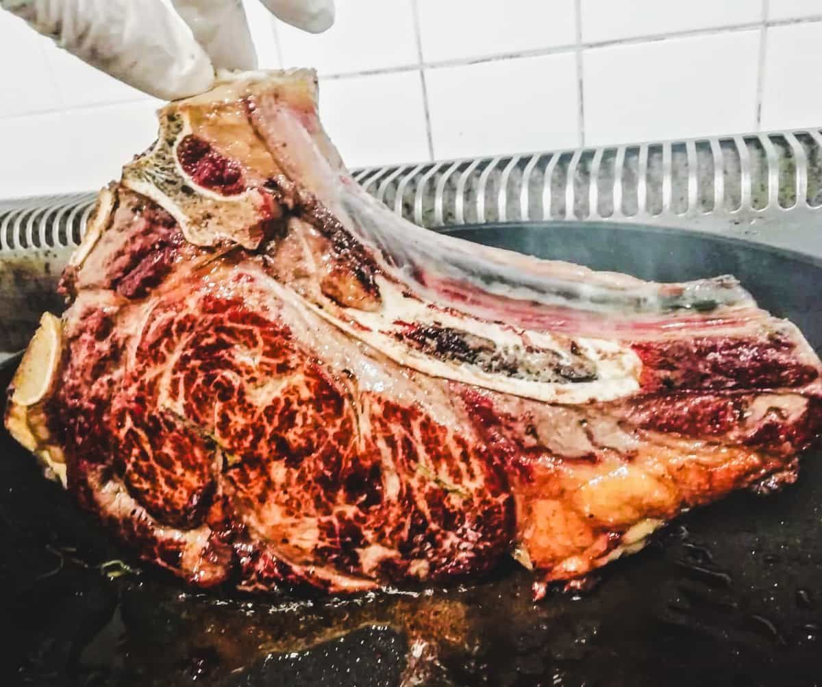 Rib steak cooking on a grill