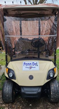 Penn Del golf cart with tan canopy and black mesh windshield parked outdoors