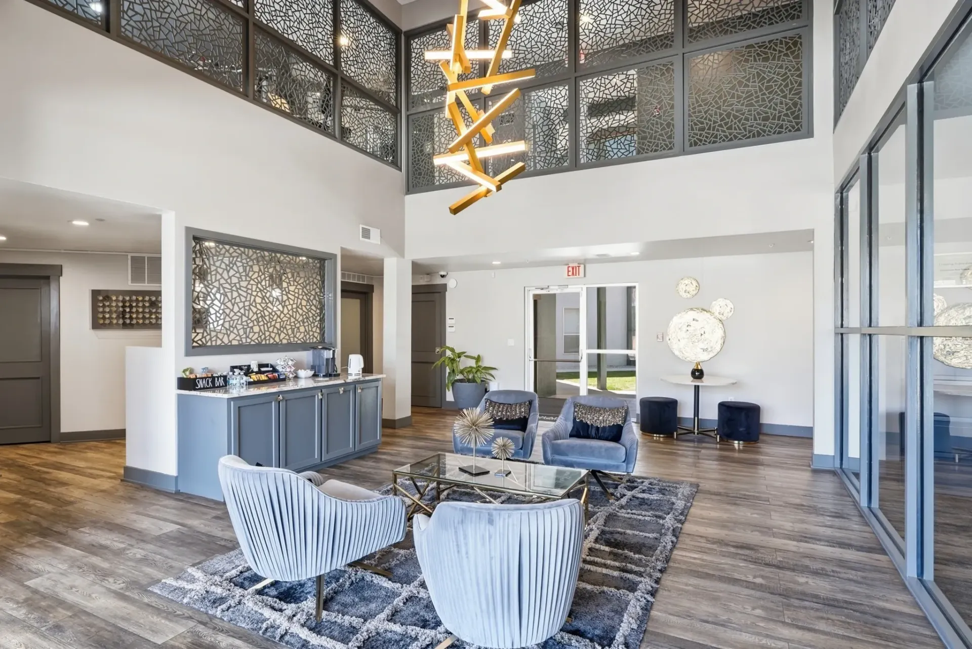 Modern lounge area with plush seating, a coffee bar, and a striking light fixture at Solaire, offering apartments in Albuquerque, NM.