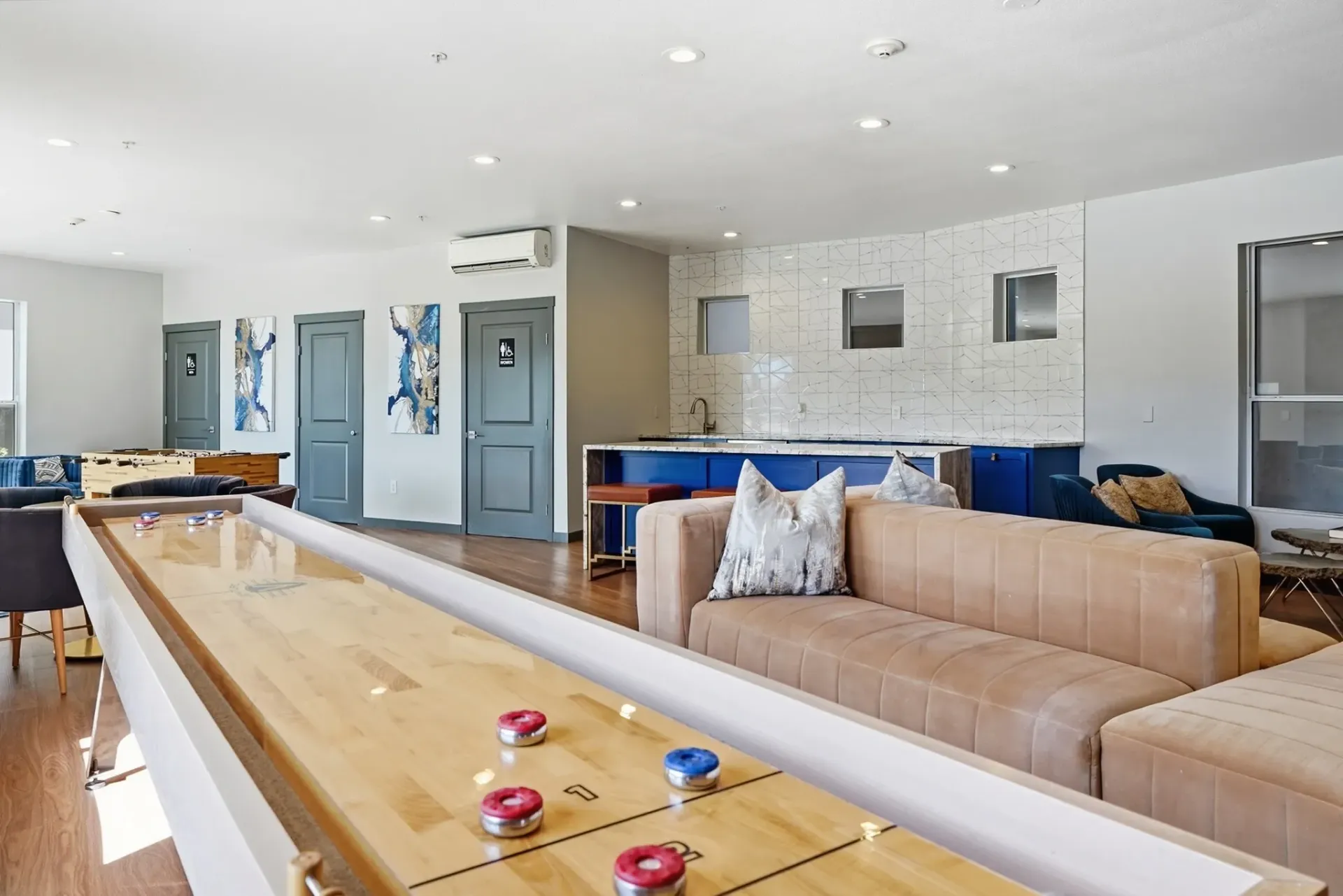 Community lounge area with shuffleboard and foosball tables.