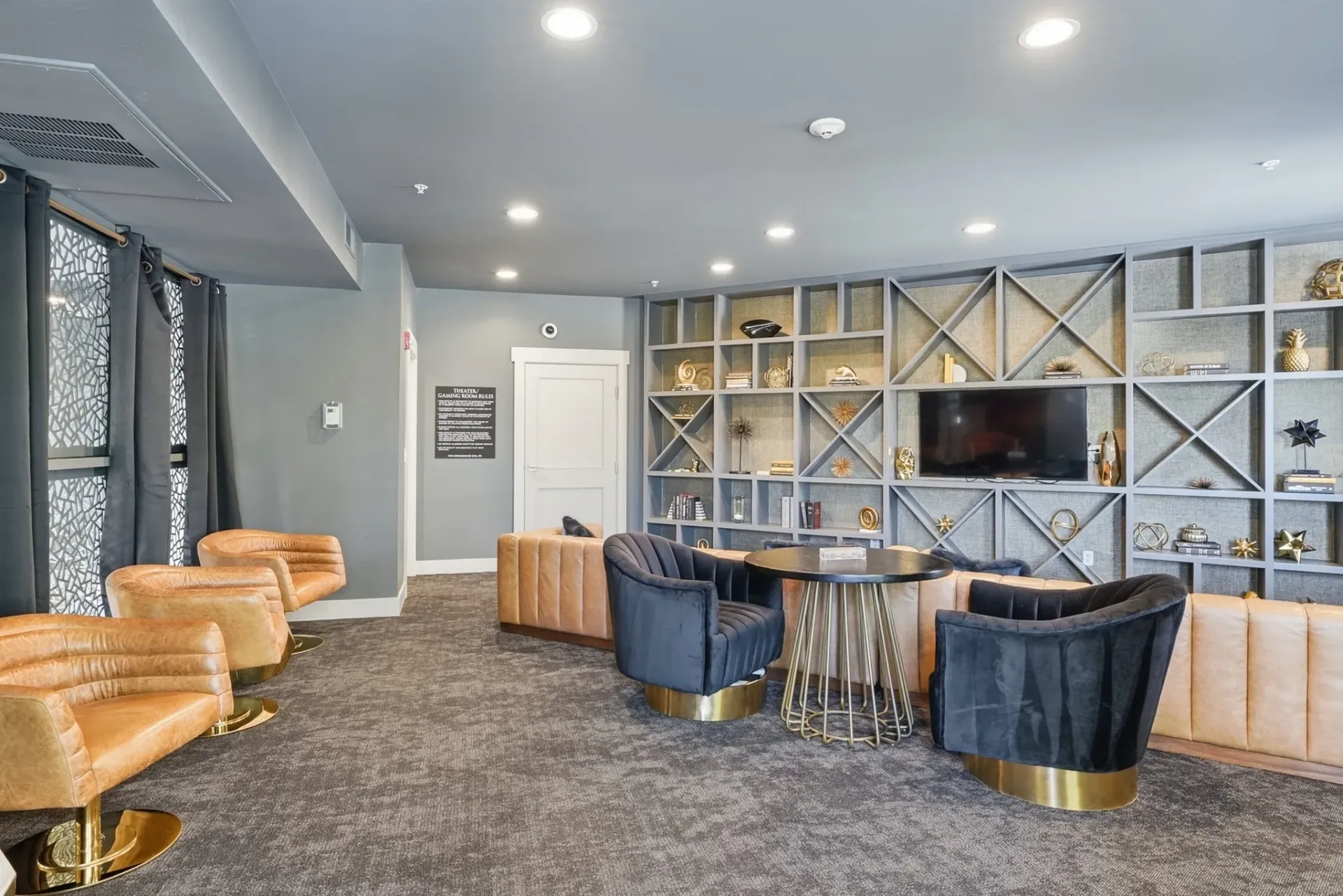 Lobby seating area with modern furniture and built-in shelving unit.
