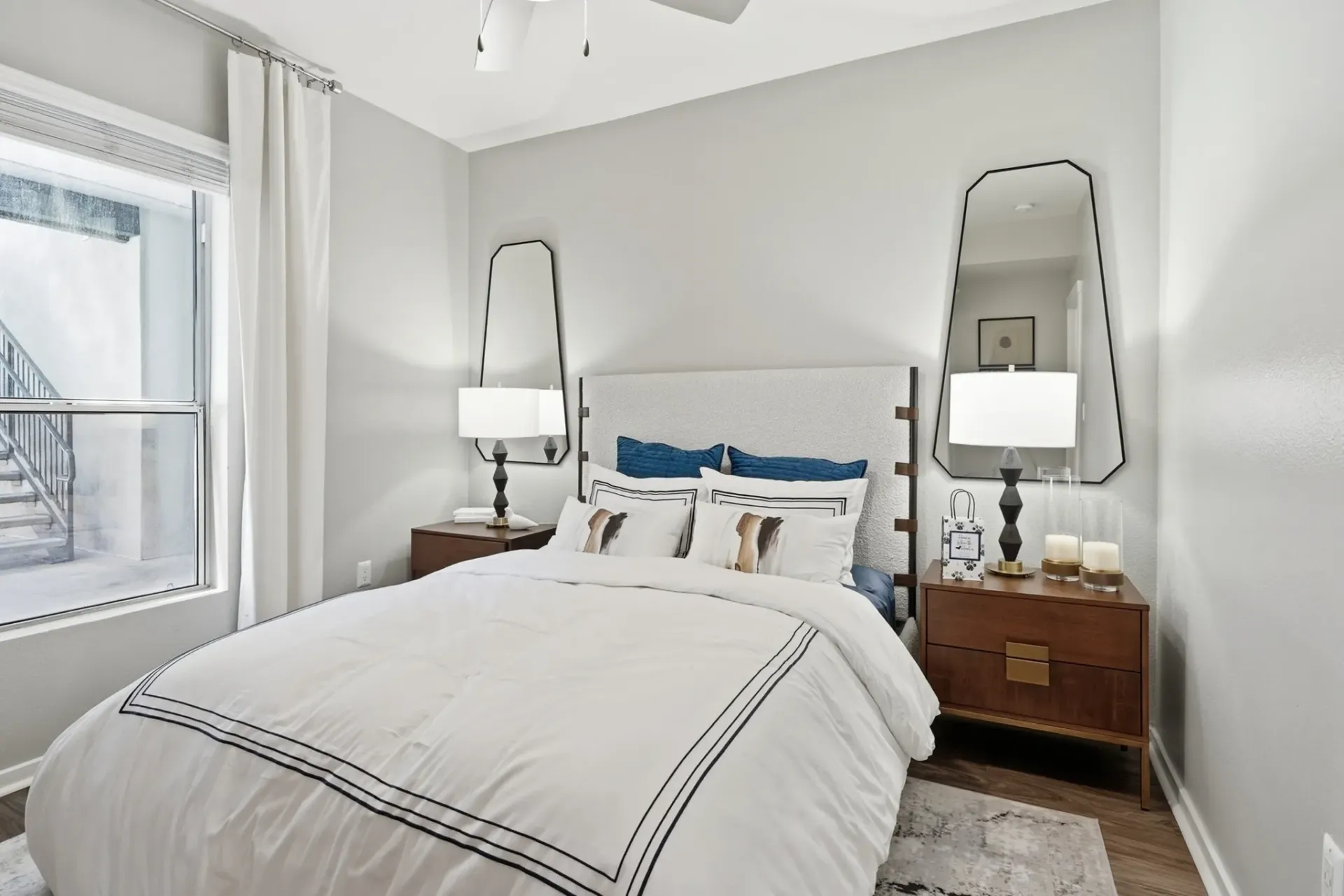 Modern bedroom with a king-size bed, white bedding, and bedside tables at Solaire, offering apartments in Albuquerque, NM.