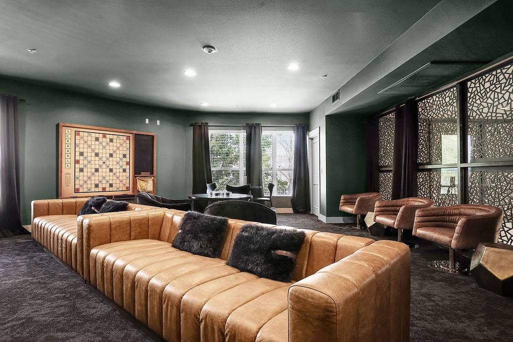 Interior resident lounge with a tan sectional sofa, chairs, and a wall-mounted game board at Solaire Luxury Apartments, offering apartments in Albuquerque, NM.