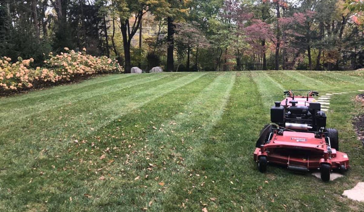 Red Lawn Mower in Green Lawn — Saint Louis, MO — Zerr Lawn Care & Landscape LLC Red Lawn Mower in Green Lawn — Saint Louis, MO — Zerr Lawn Care & Landscape LLC