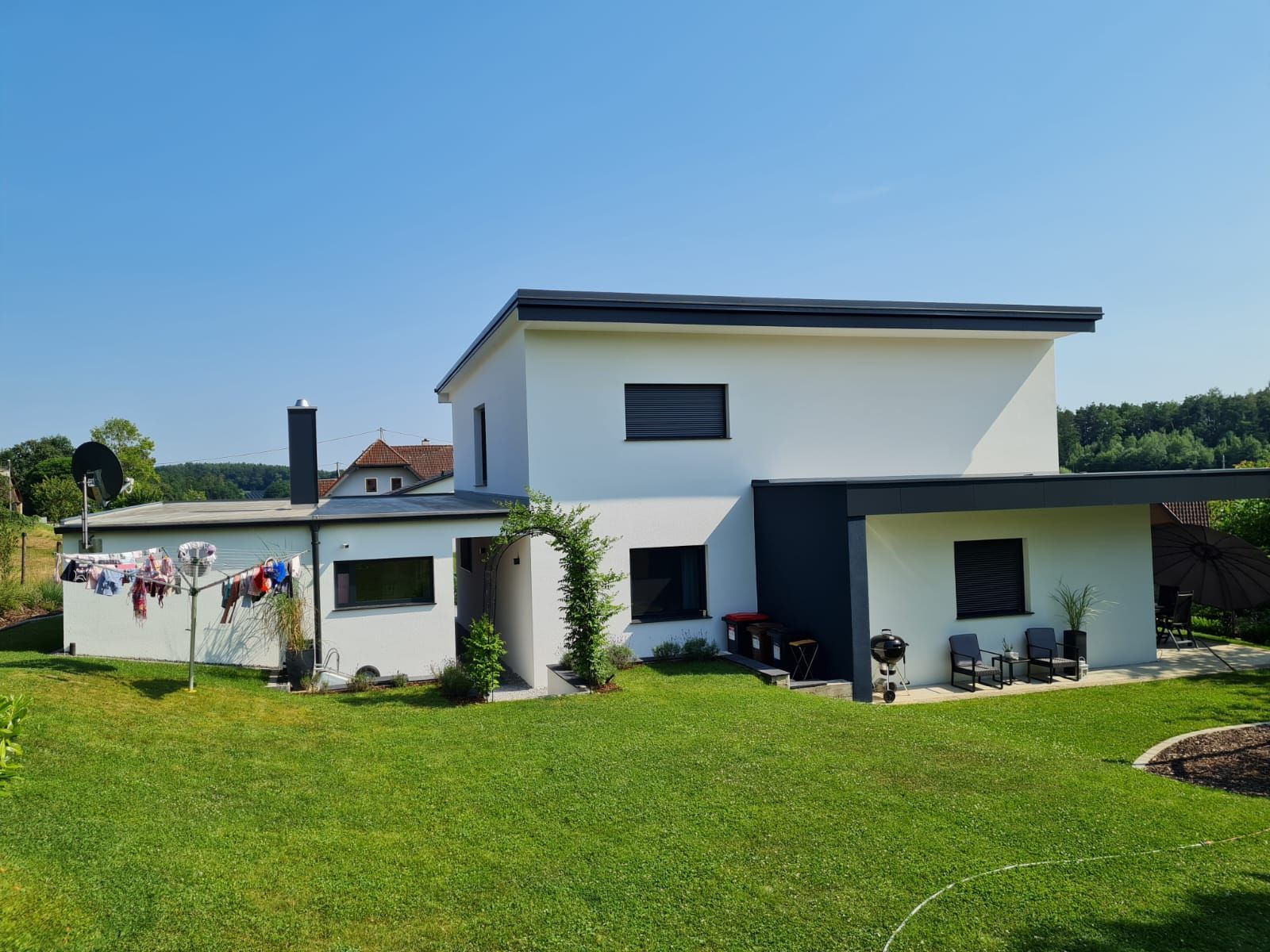 Ein weißes Haus mit einer großen Wiese davor.