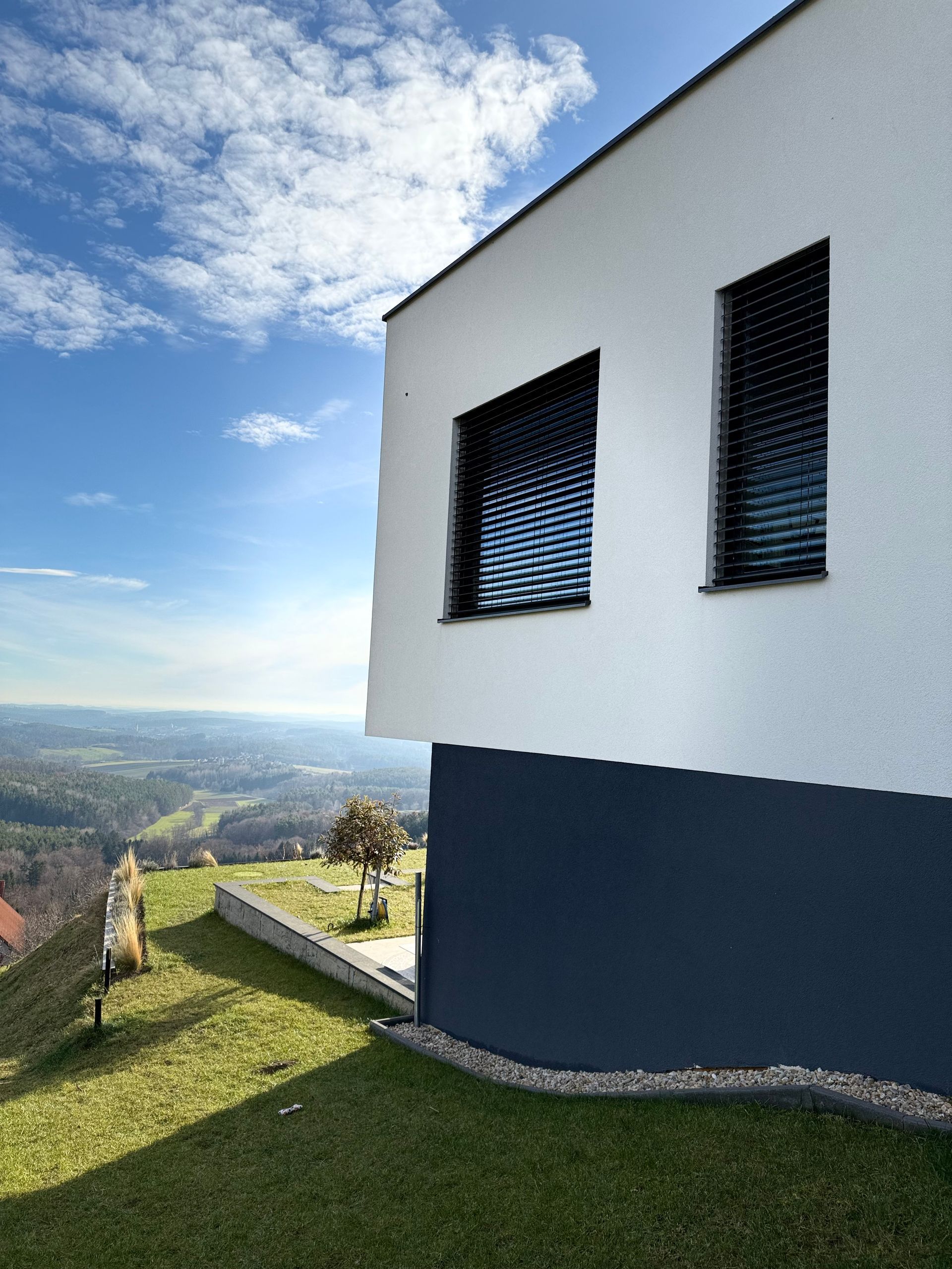 Ein weiß-blaues Haus mit Blick auf die Landschaft