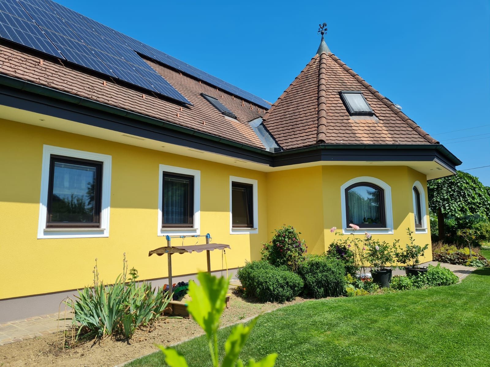 Ein gelbes Haus mit einem Dach, auf dem sich Solarzellen befinden.