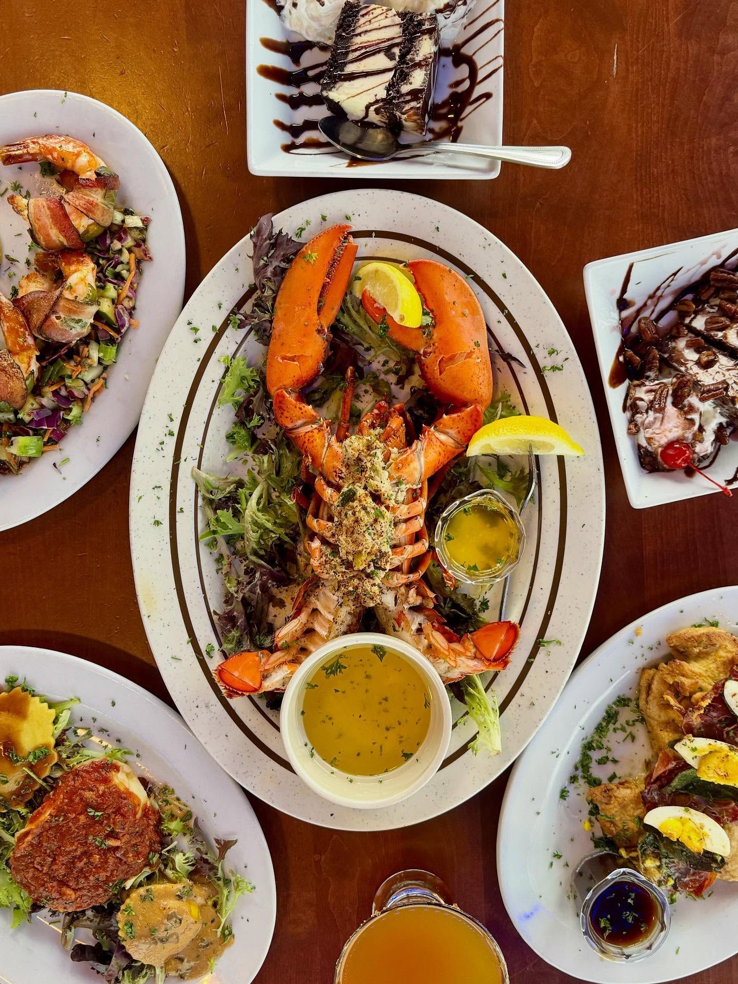 Assorted seafood dishes on a table, including lobster and sauces, arranged on plates.