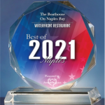 Glass trophy with a blue and pink faceted top reading “Best of 2021,” on a clear base.