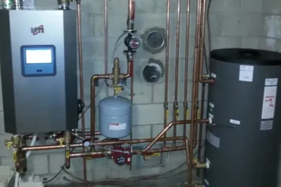 A room with a water heater and a water tank