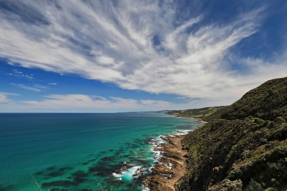 A Cliff Overlooking the Ocean with A Blue Sky and Clouds — Sunworks Eco Plumbing In Apollo Bay, VIC