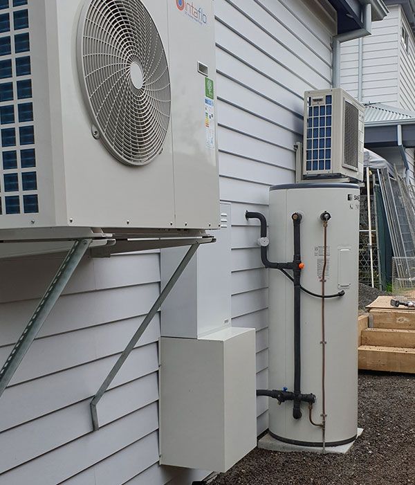 A Heat Pump and A Water Heater on The Side of A Building — Sunworks Eco Plumbing In Torquay, VIC