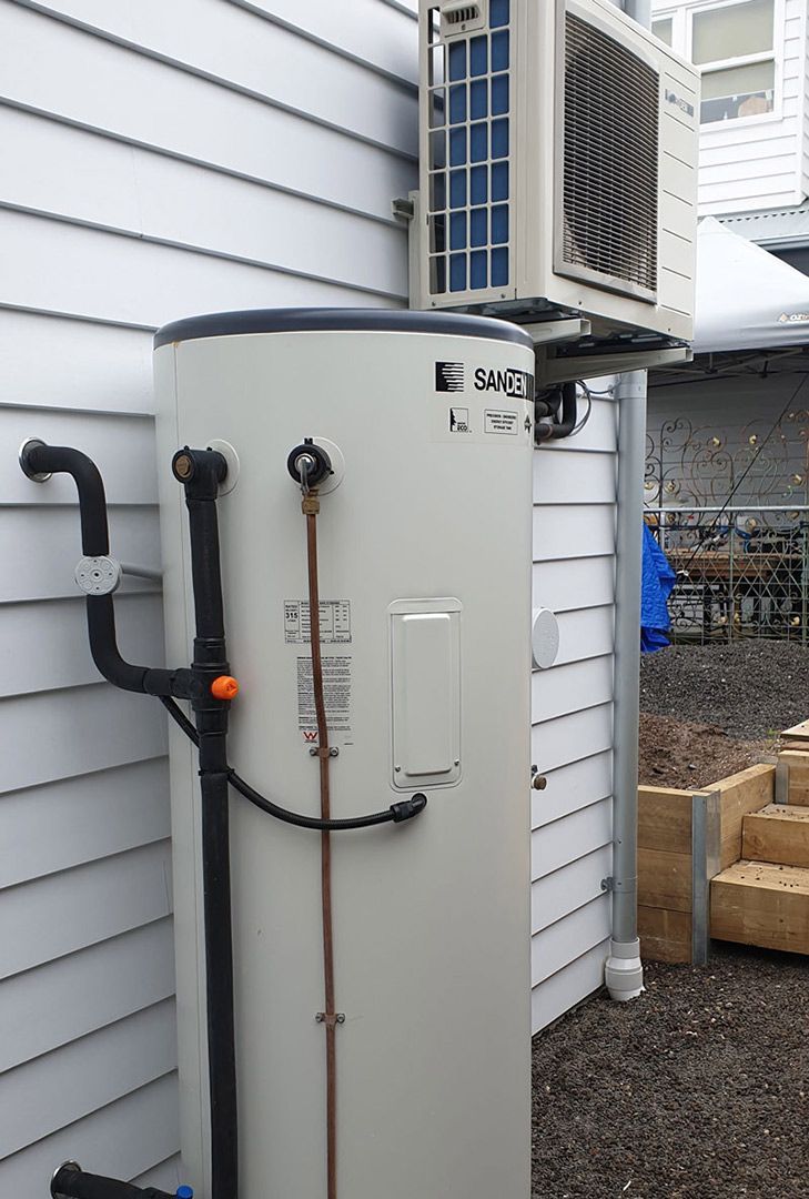 A Heat Pump Is Attached to The Side of A House — Sunworks Eco Plumbing In Altona, VIC