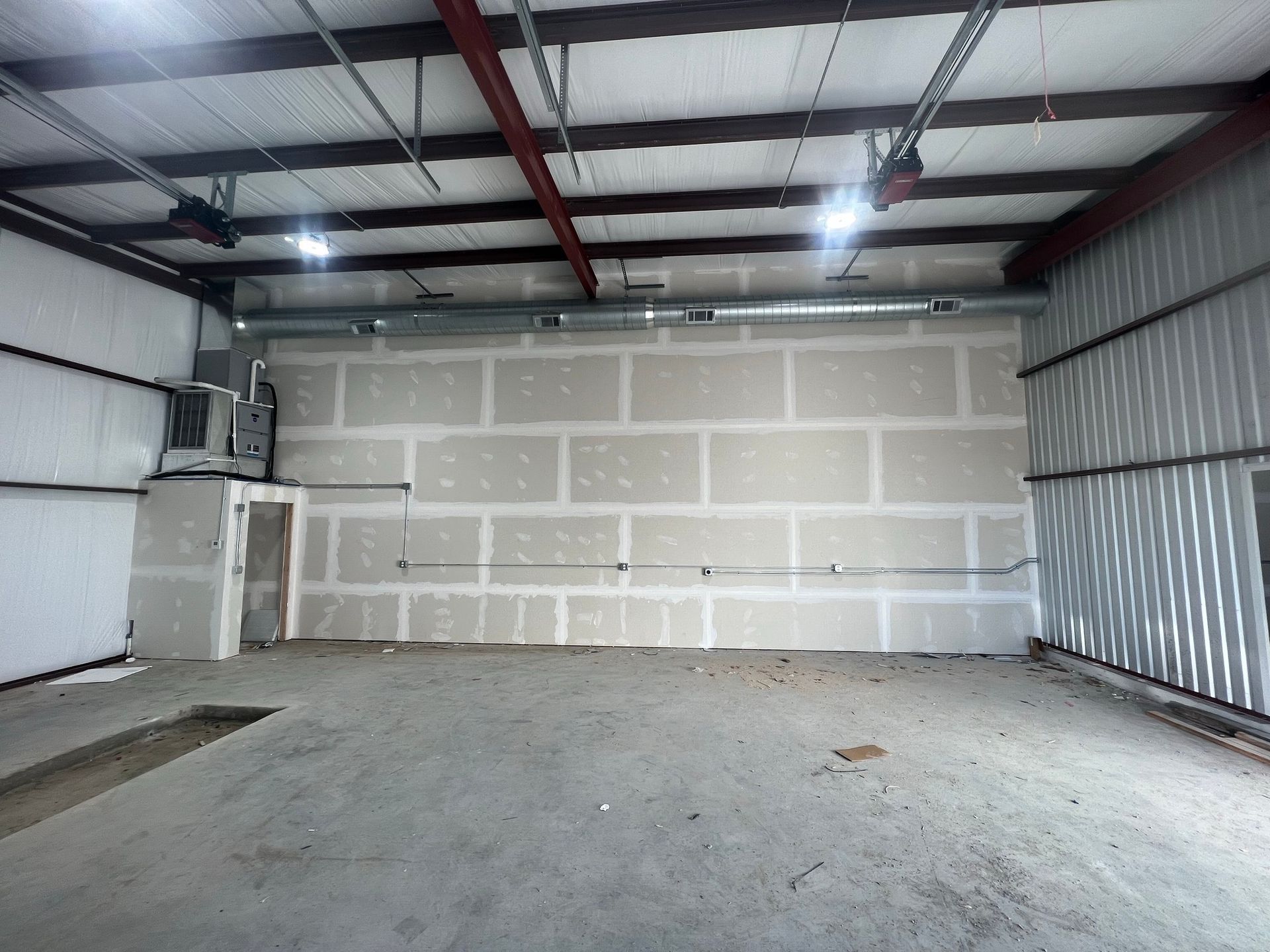 An empty garage with a brick wall and a ceiling fan