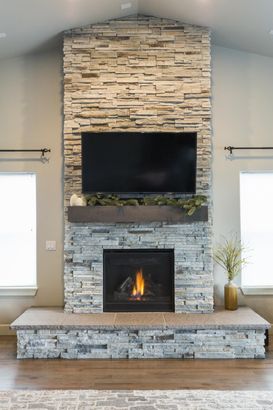 A living room with a fireplace and a flat screen tv on the wall.