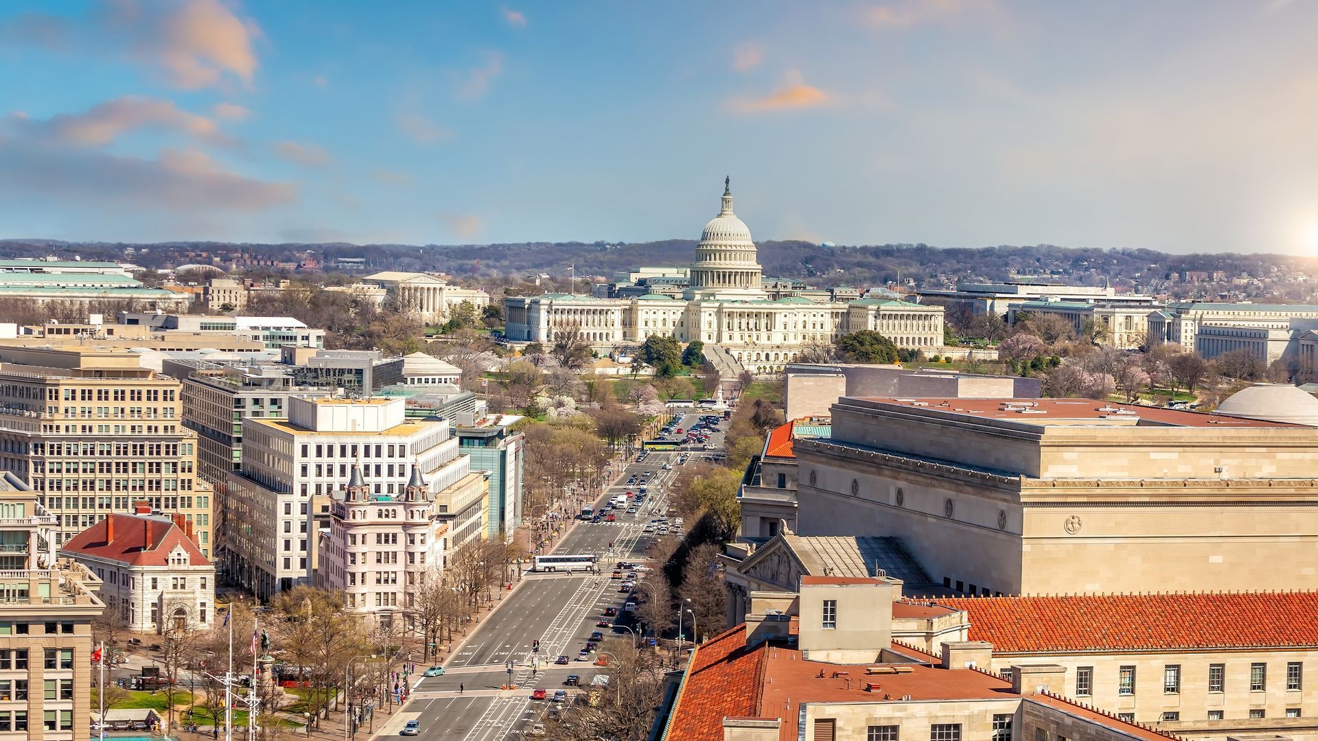 Aerial view of Washington, D.C. with the U.S. Capitol centered beyond a broad city avenue