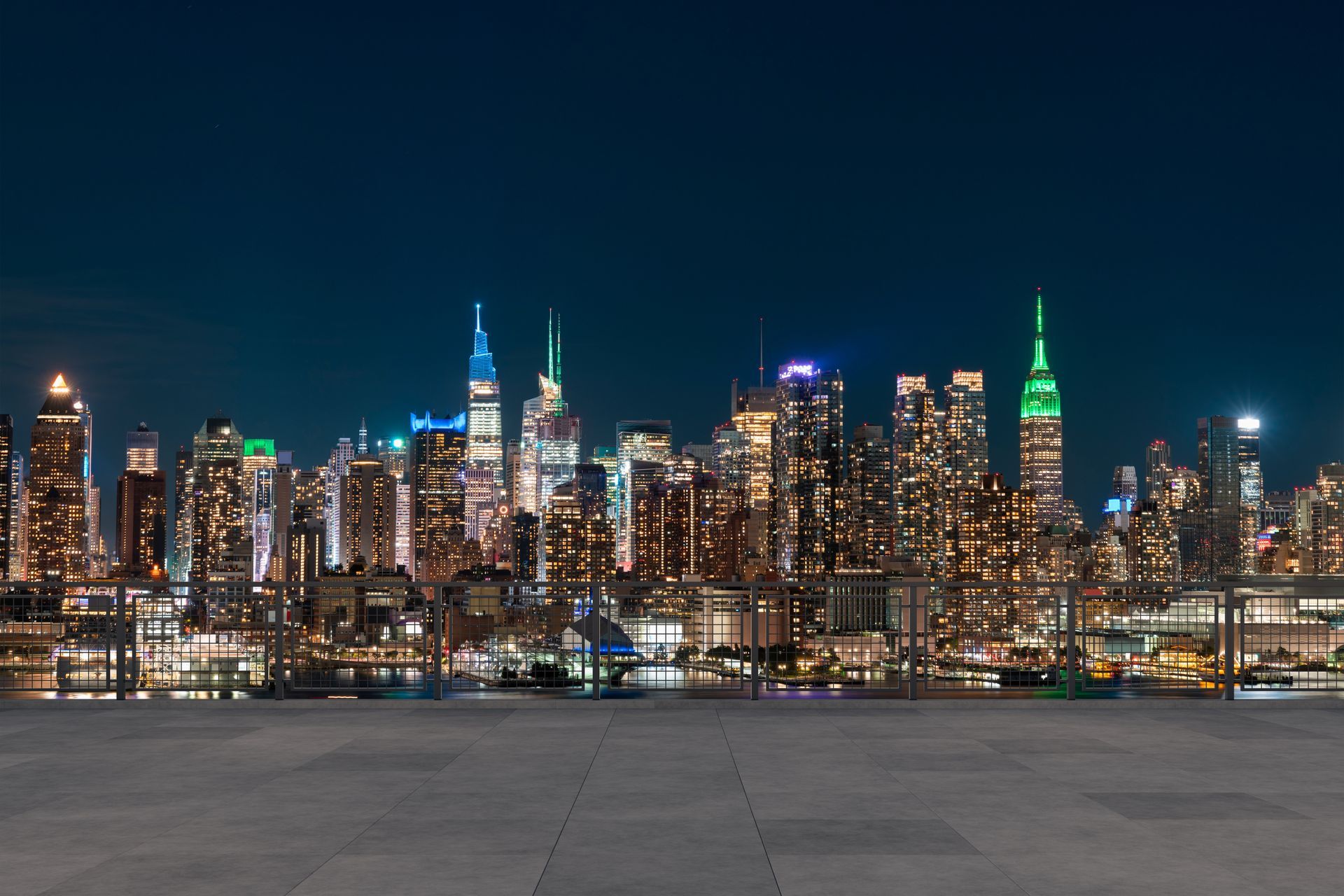 Nighttime city skyline with illuminated skyscrapers and a waterfront in the foreground