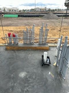 A construction site with a lot of pipes and buckets on the ground.