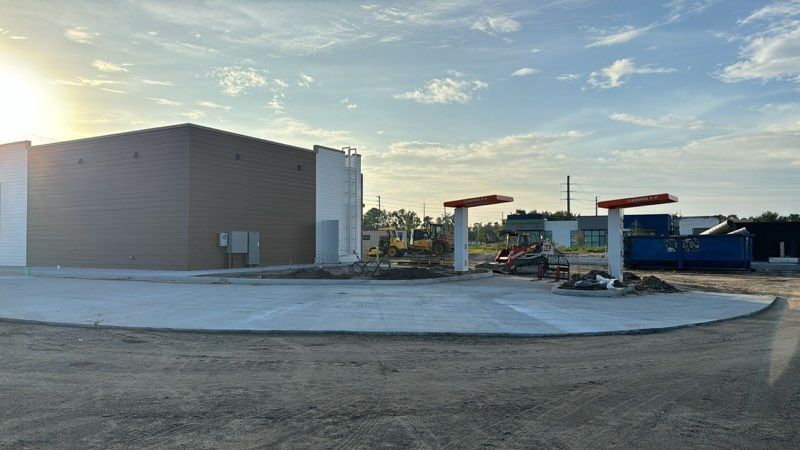 A large building is being built in the middle of a dirt field.
