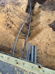 A bunch of wires are laying in the dirt.