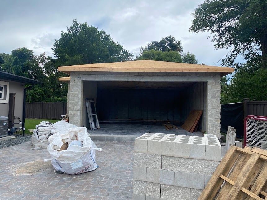 A garage is being built in the backyard of a house.