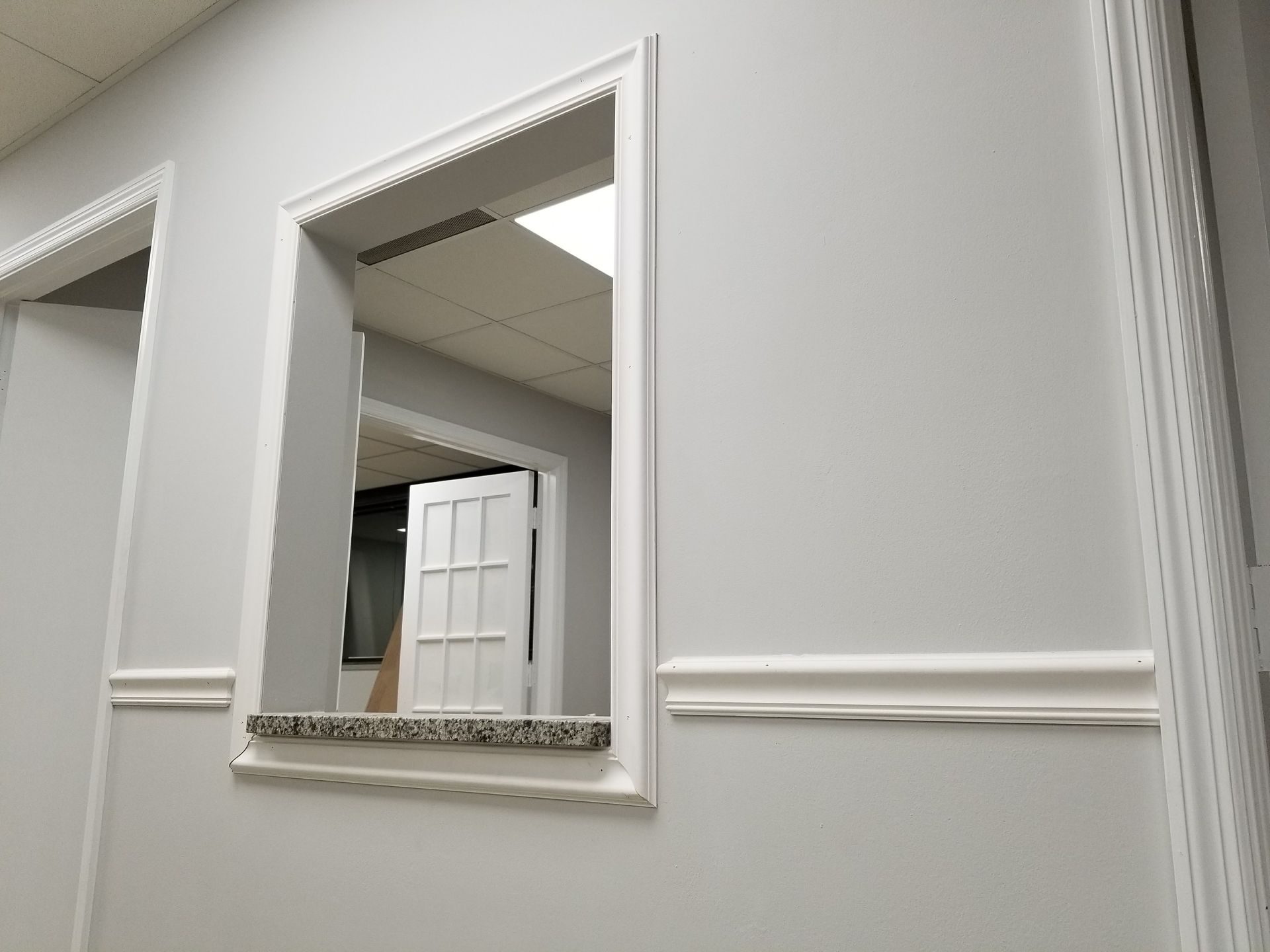 A white wall with a window and a door
