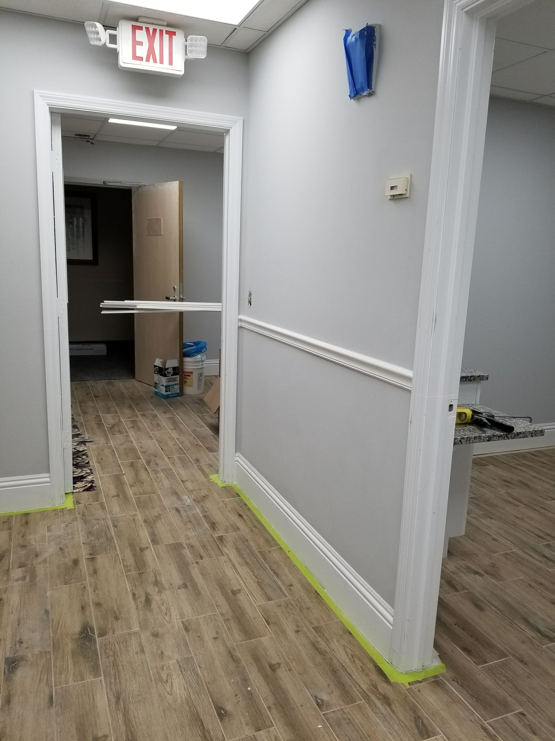 A hallway with a red exit sign above it