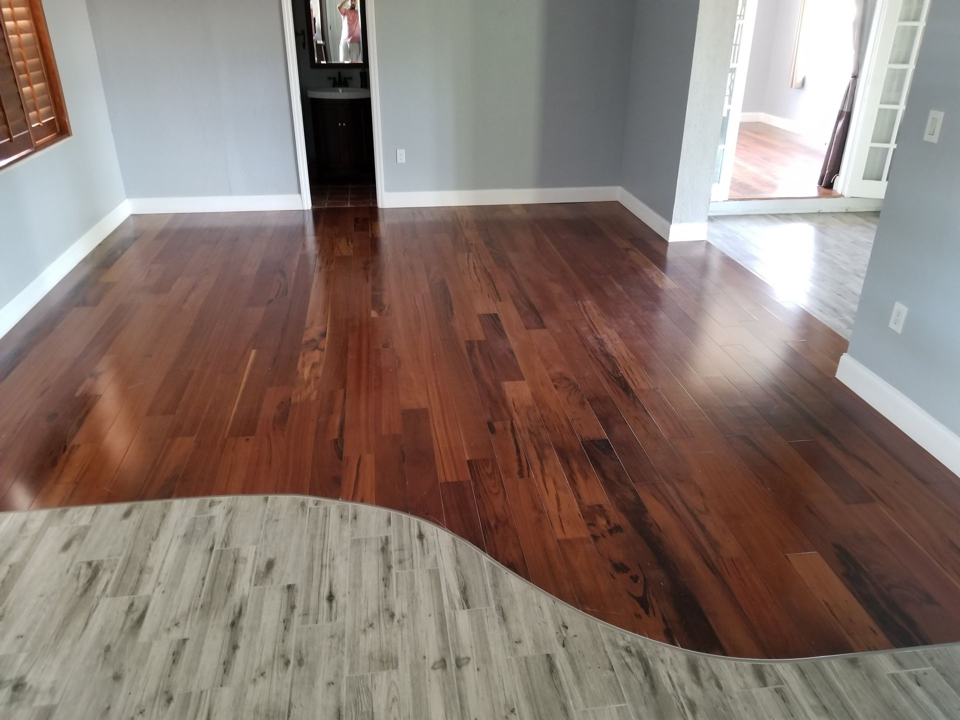 A living room with hardwood floors and a rug on the floor.