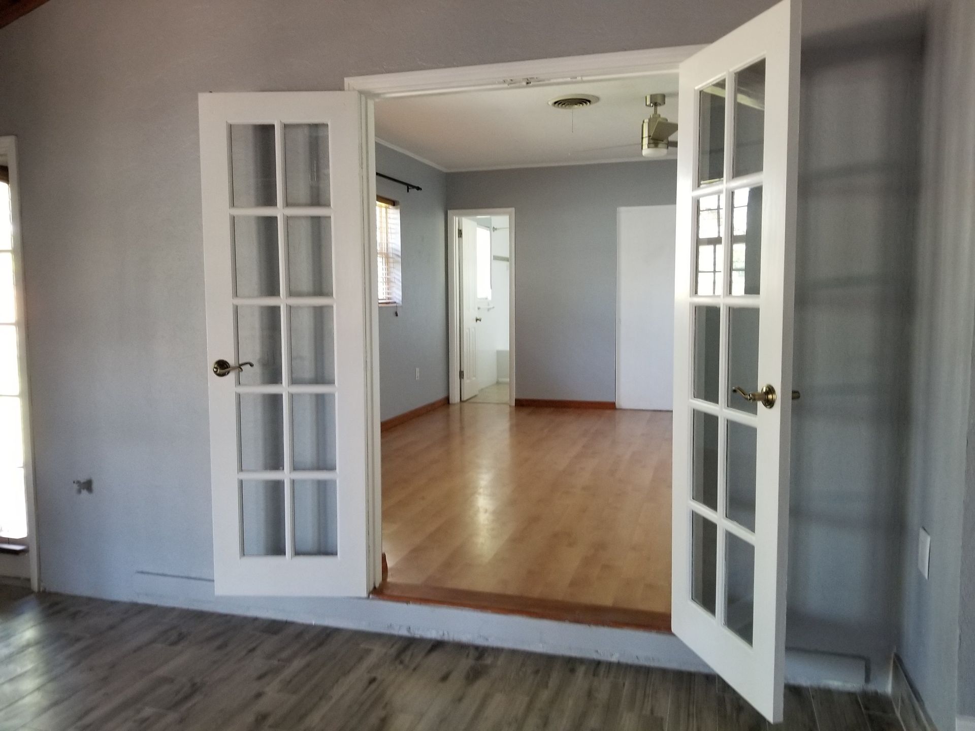 An empty living room with french doors open