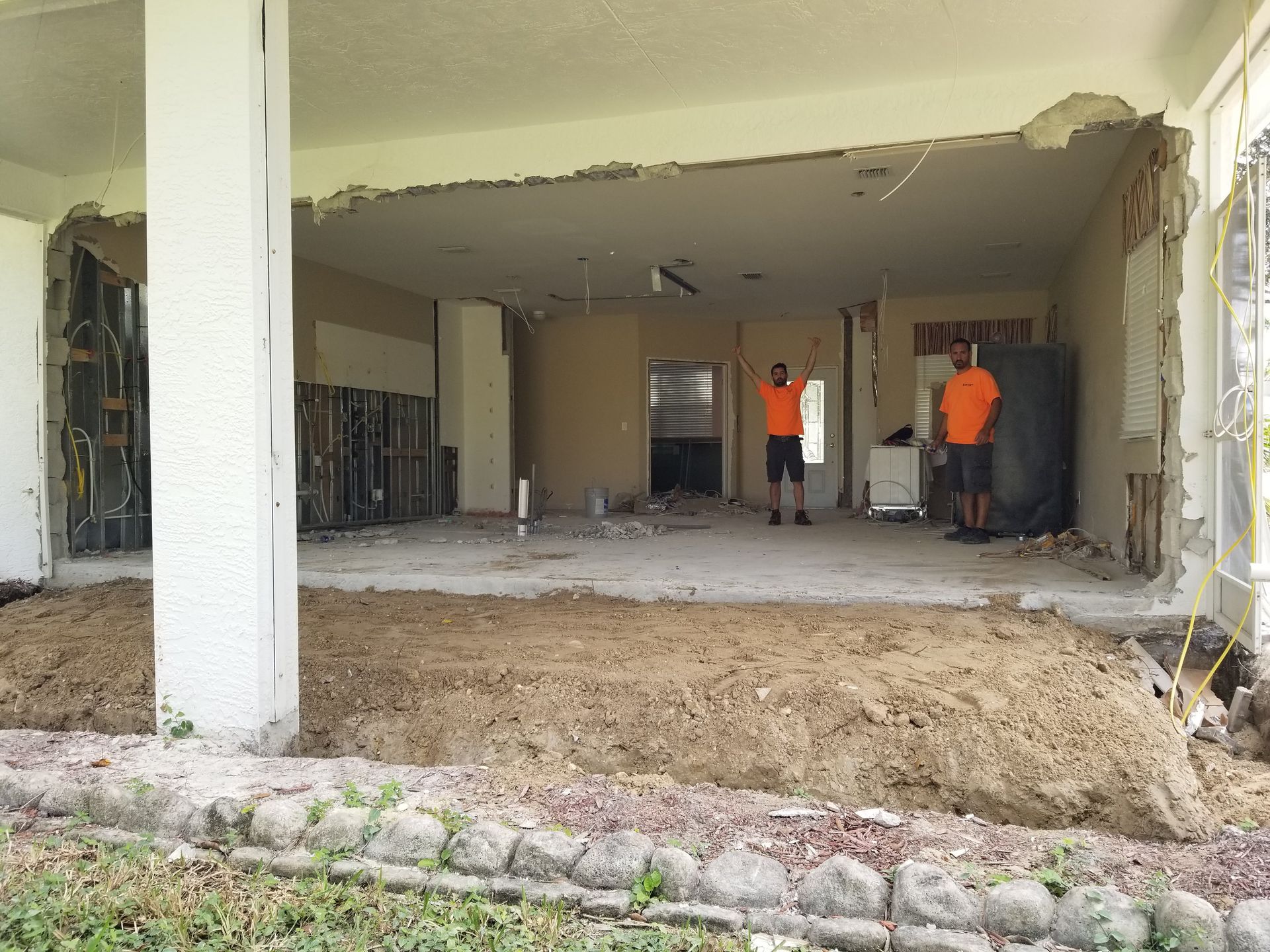 Two men are standing in a room that is being remodeled.