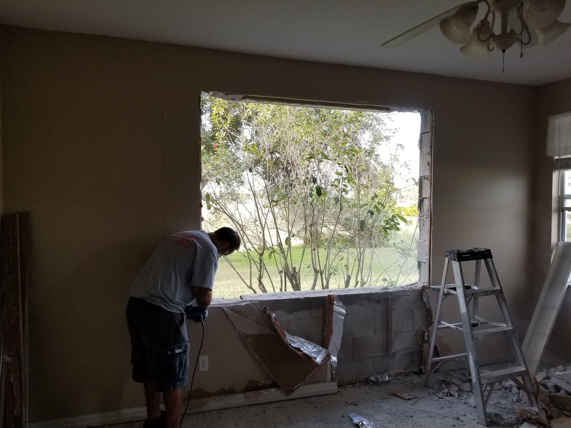 A man is standing in front of a window in a room.