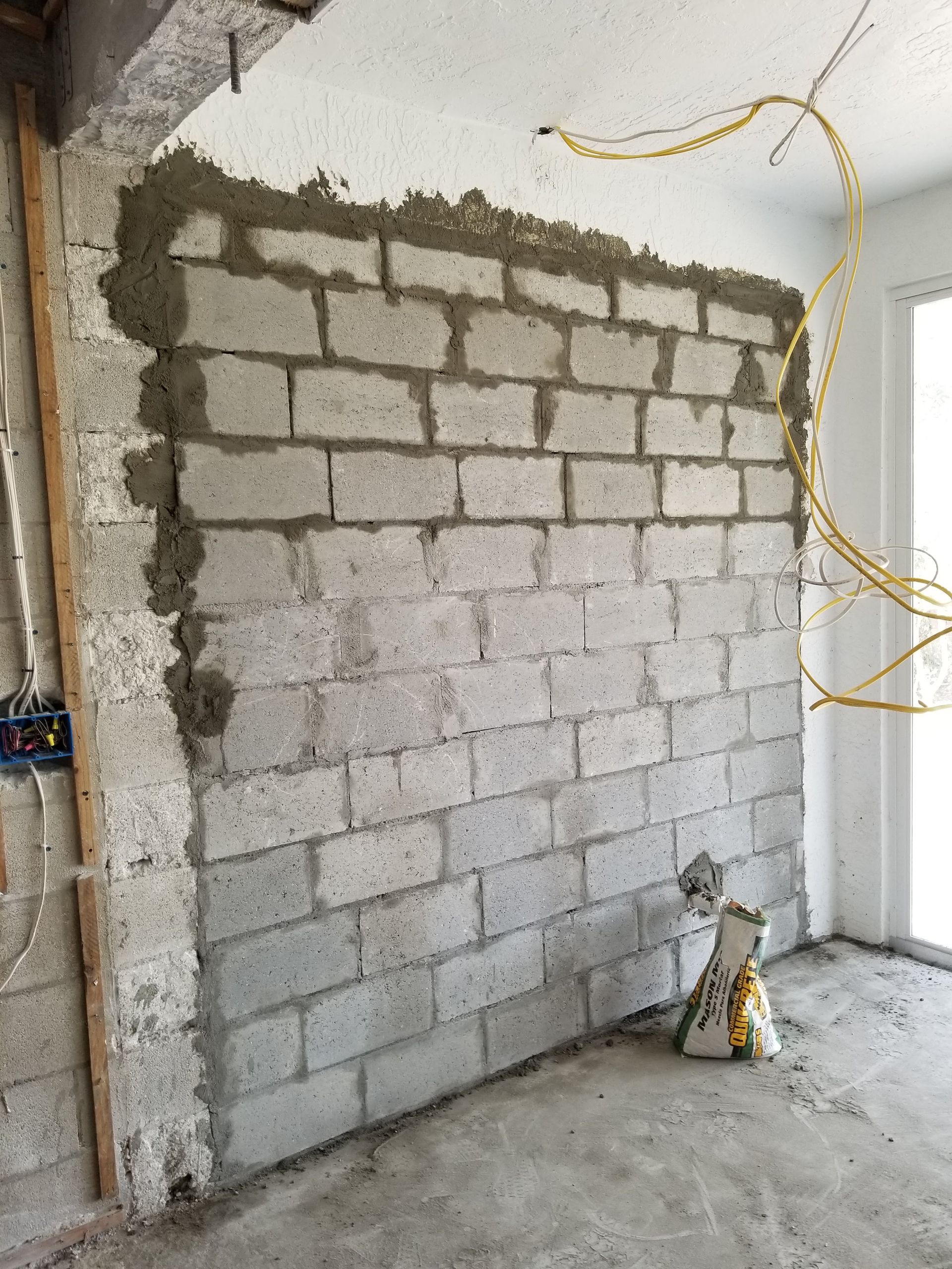 A brick wall is being built in a room.