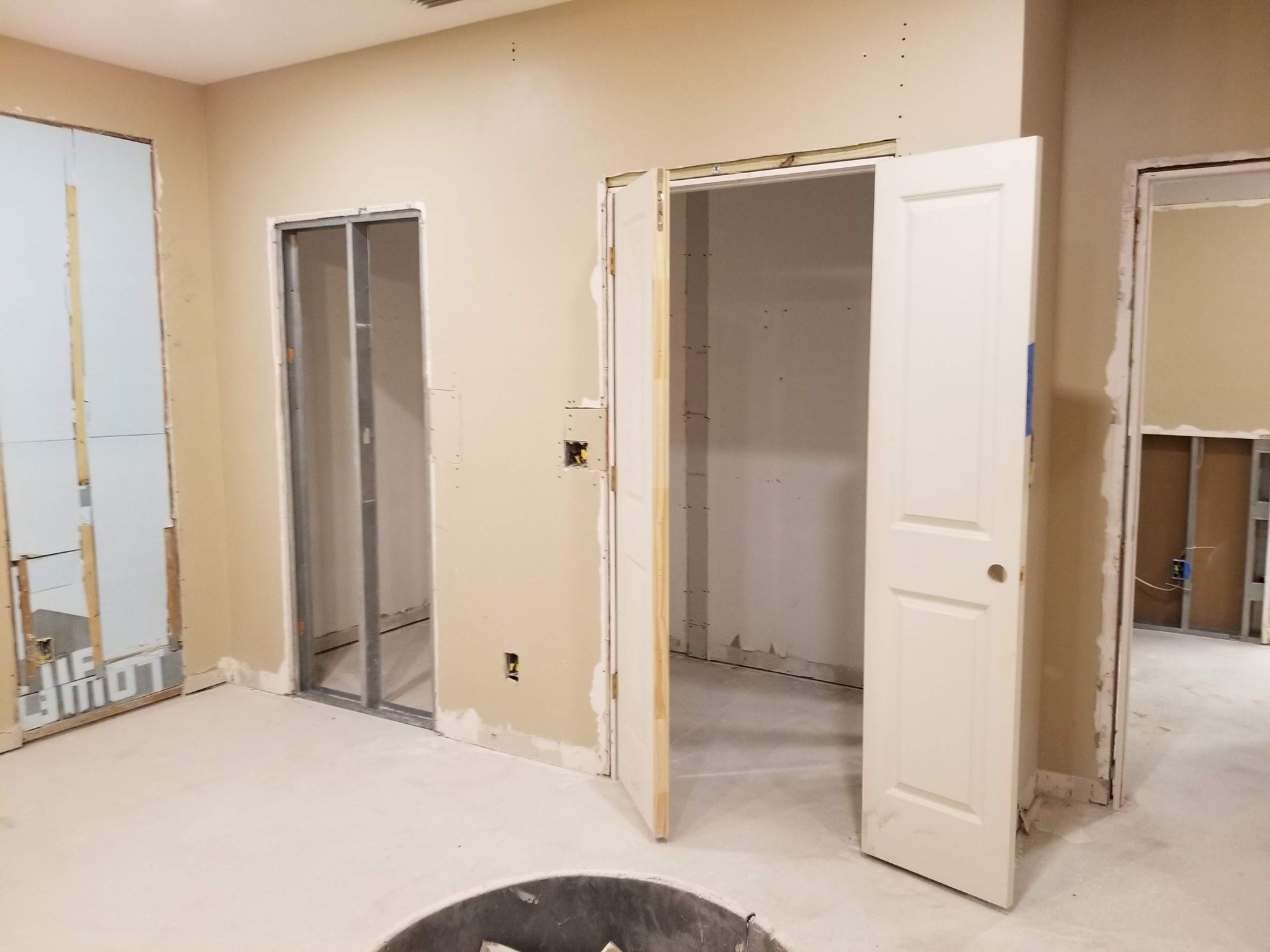 A room with a lot of doors and walls being built.
