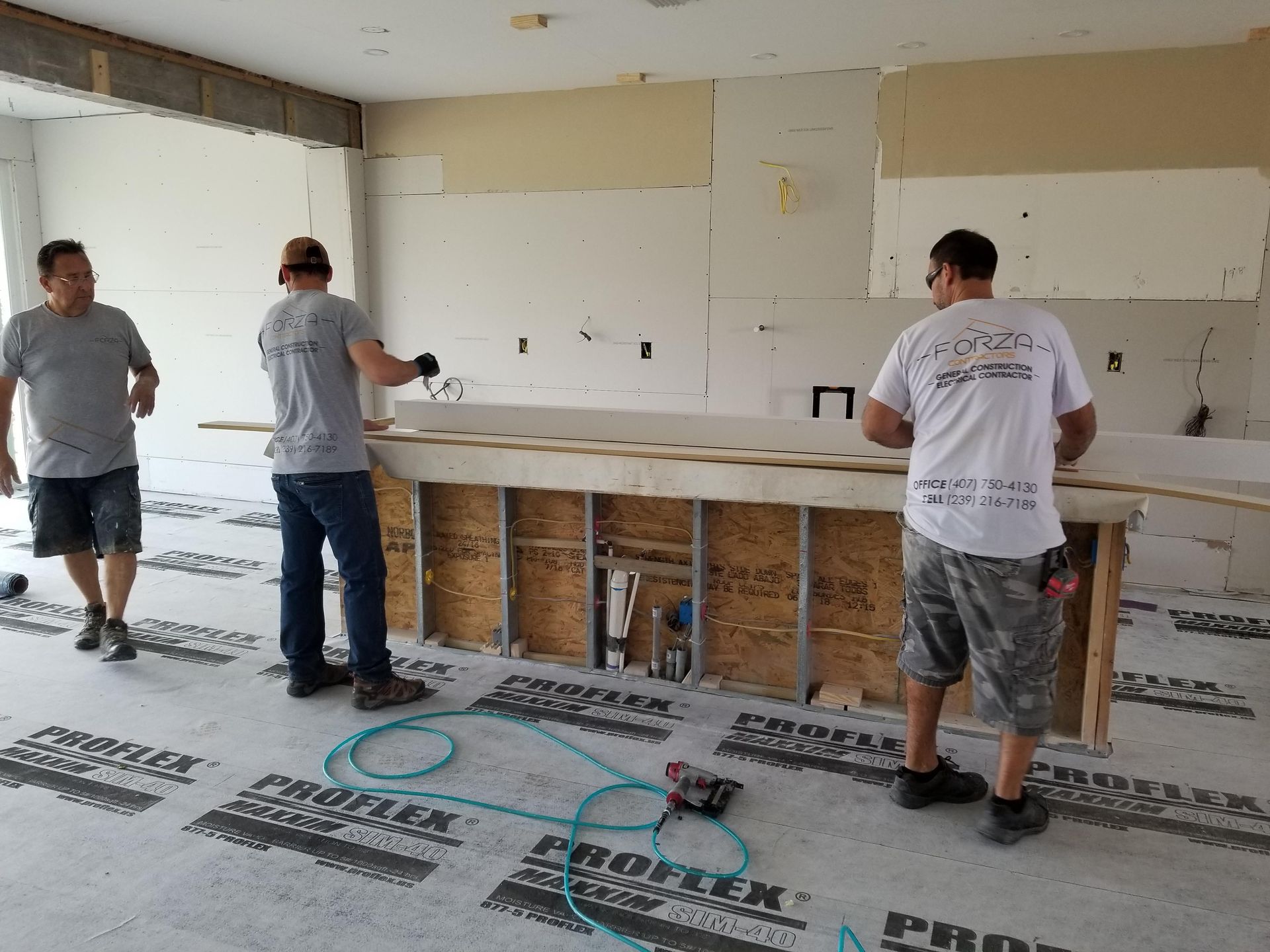 A group of men are working on a counter in a kitchen