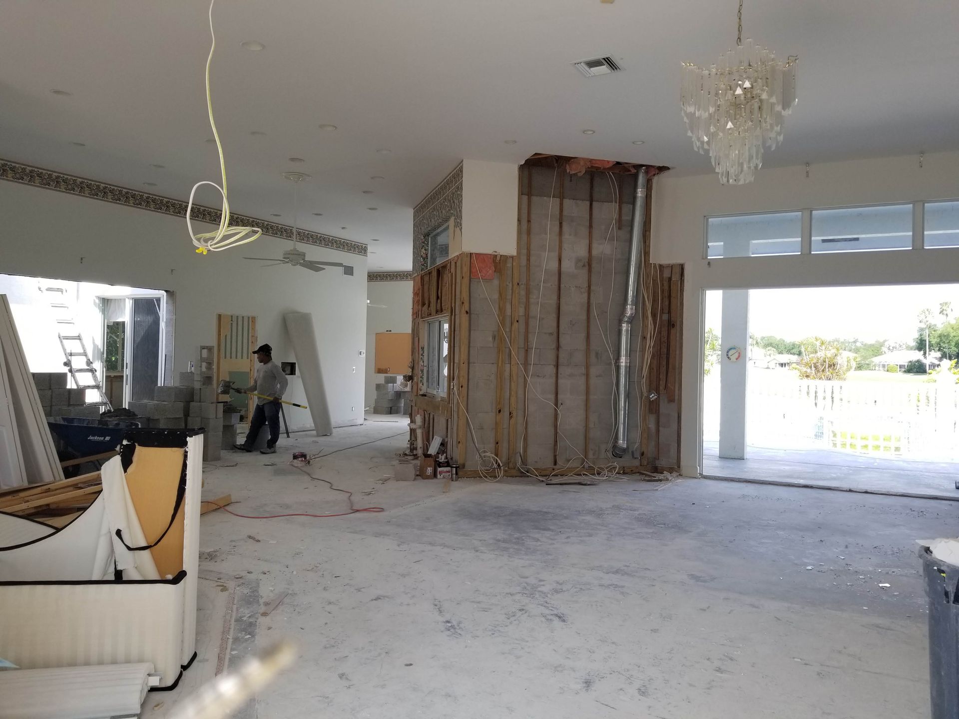 A large empty room with a chandelier hanging from the ceiling.