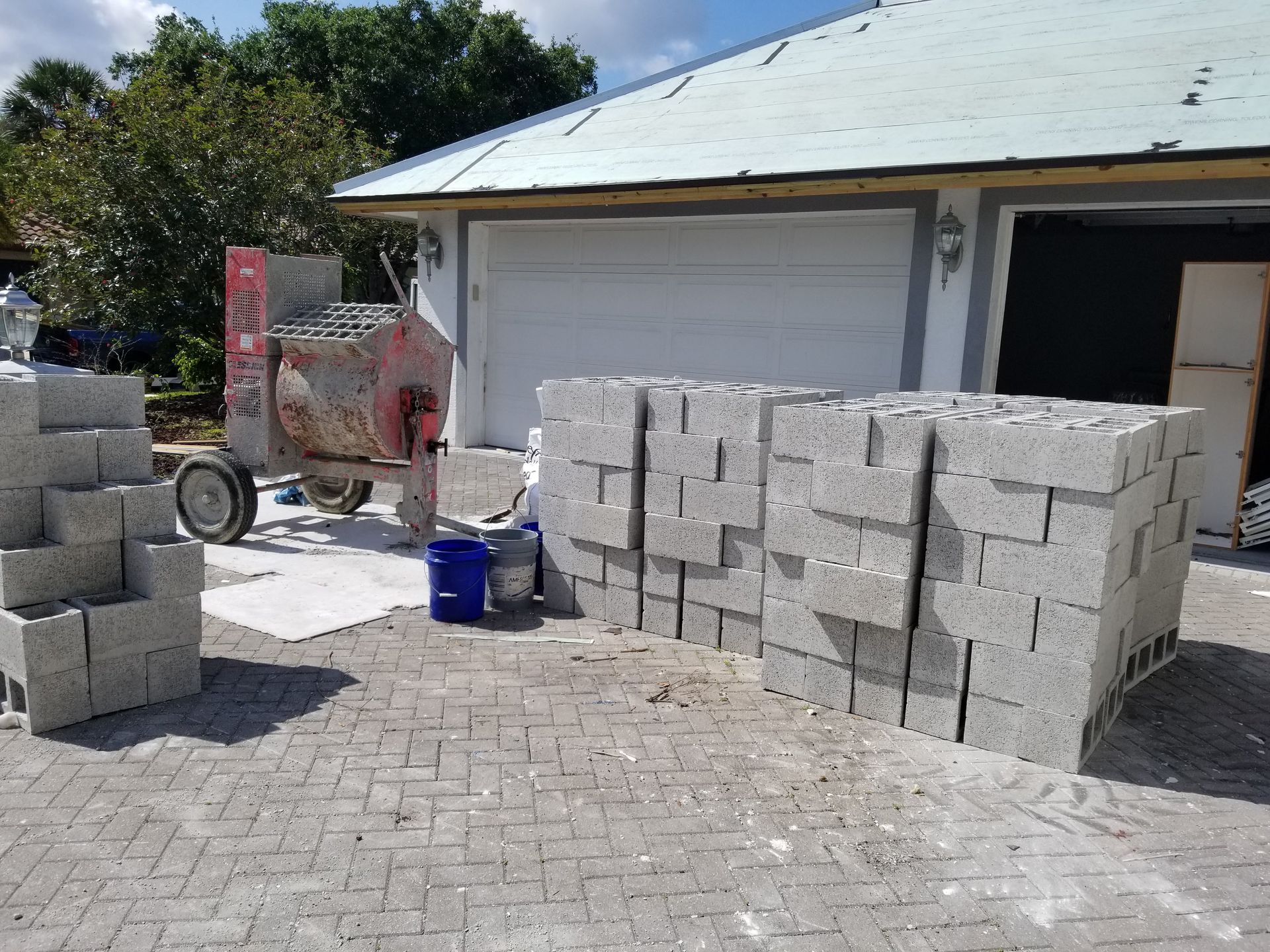 A pile of bricks is sitting in front of a garage