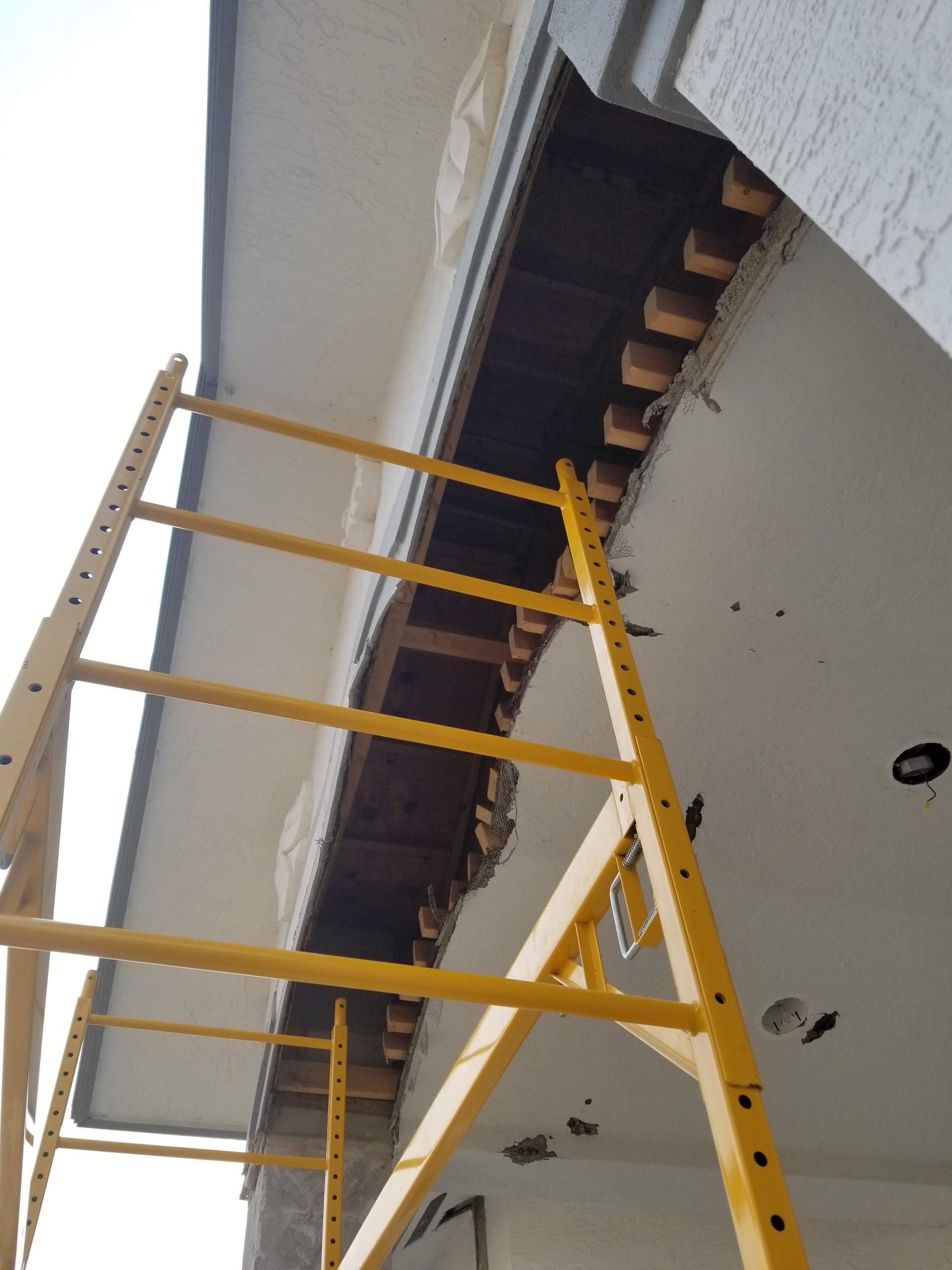 A yellow ladder is attached to the side of a building