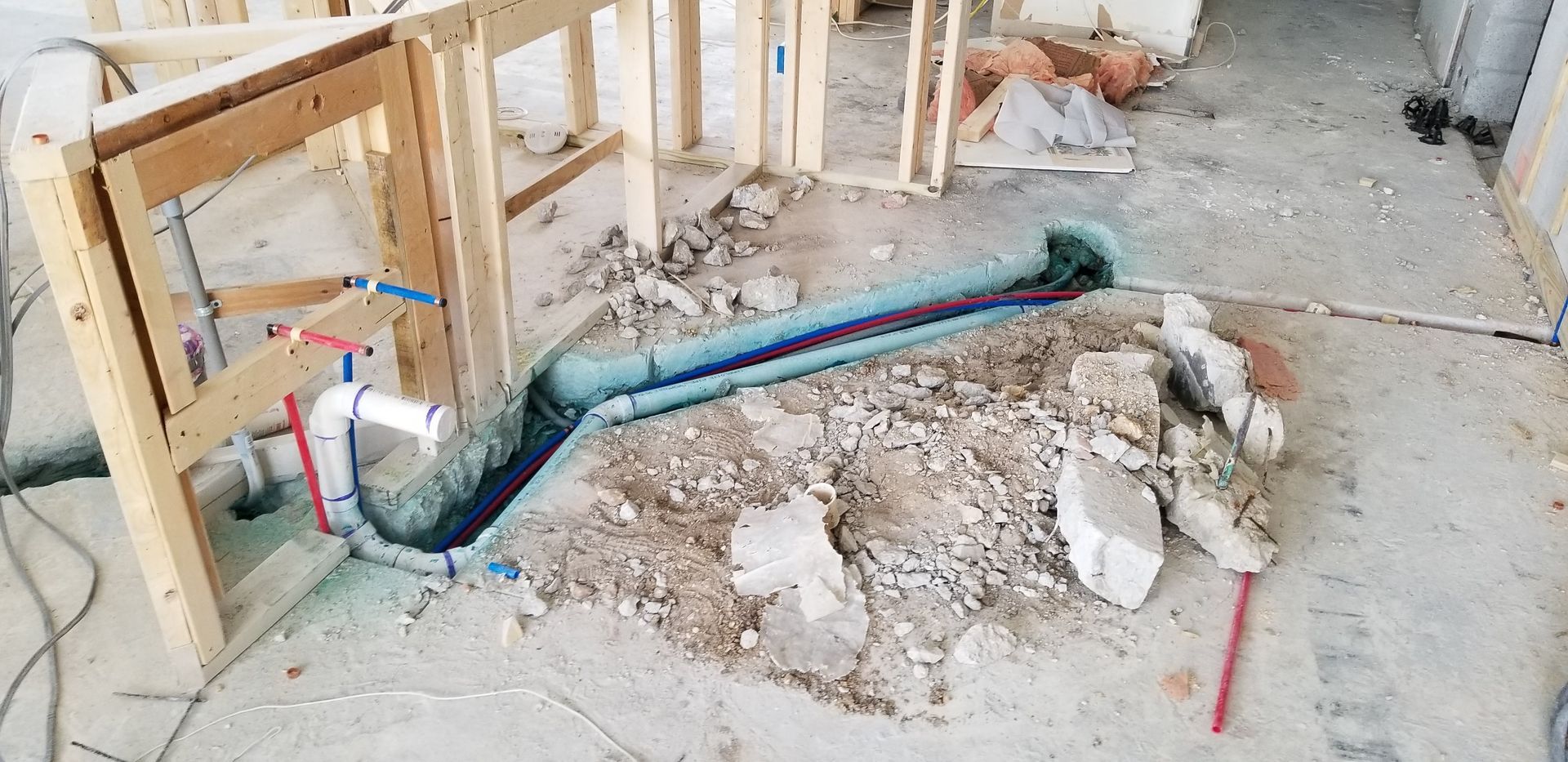 A pipe is being installed in the ground in a building under construction.