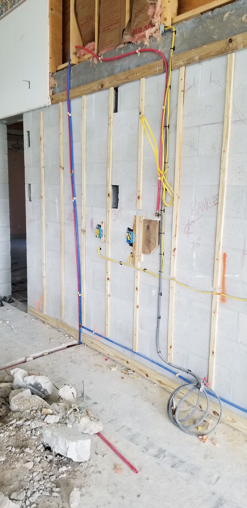 A room under construction with a lot of wires coming out of the wall.