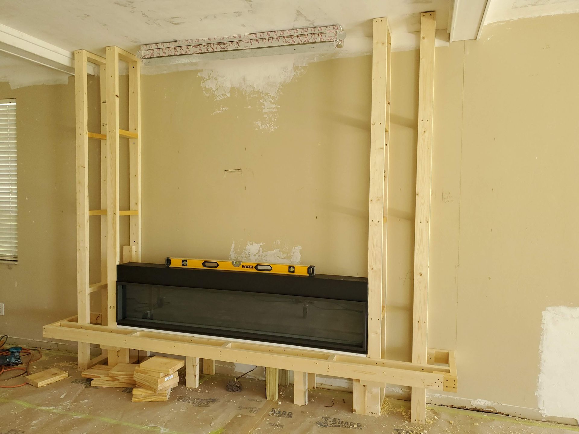 A fireplace is being built in a living room.