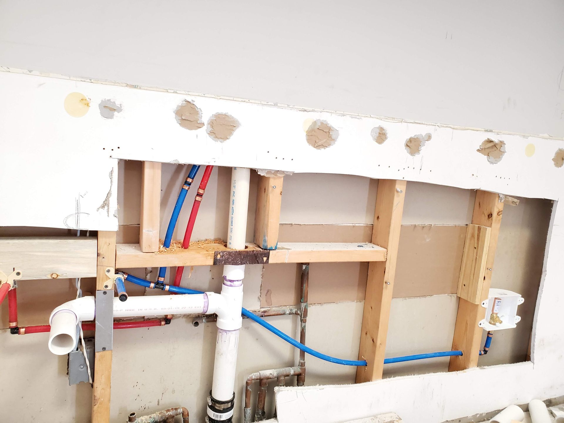 A bathroom with a lot of pipes coming out of the wall.