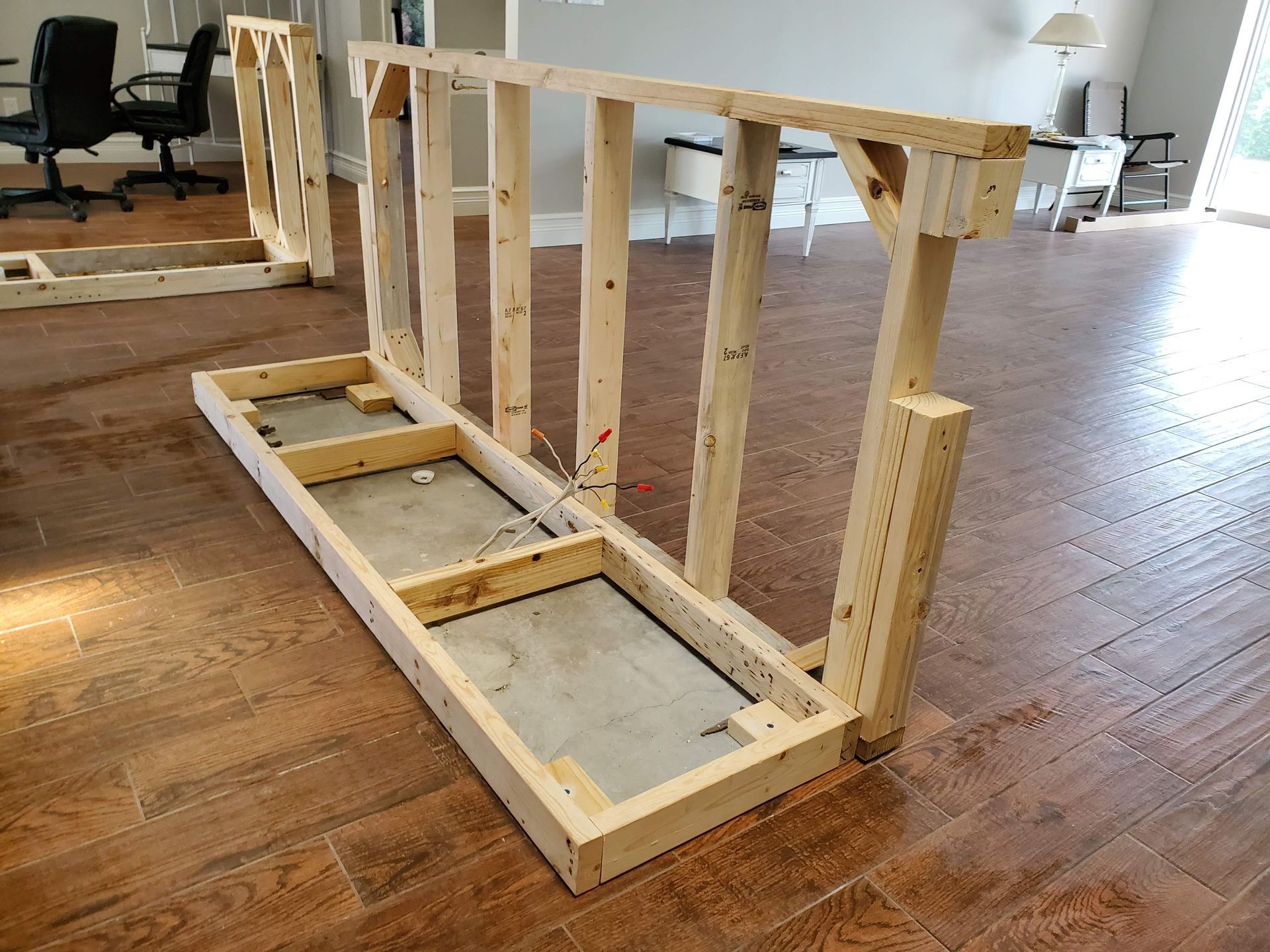 A wooden frame is sitting on a wooden floor in a room.
