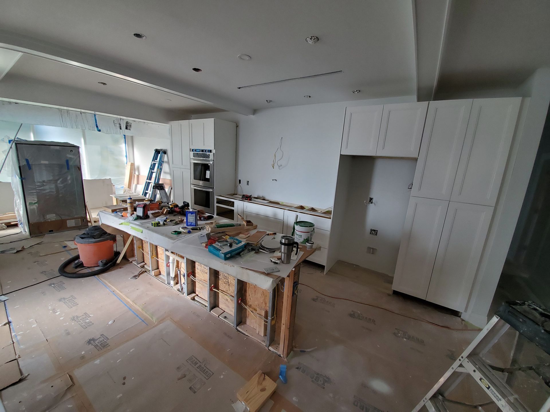 A kitchen under construction with a large island in the middle of the room.
