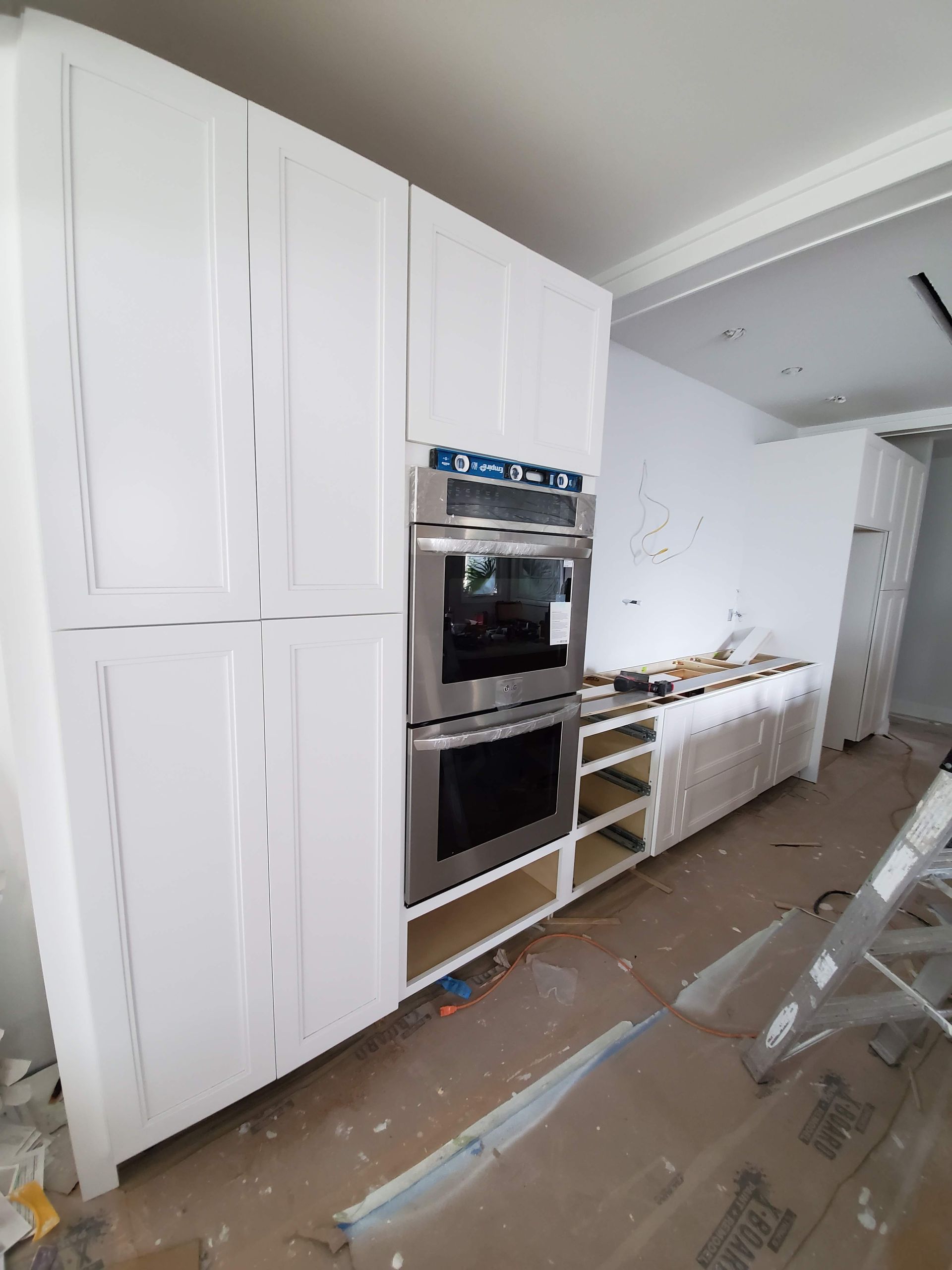 A kitchen with white cabinets and a stainless steel oven