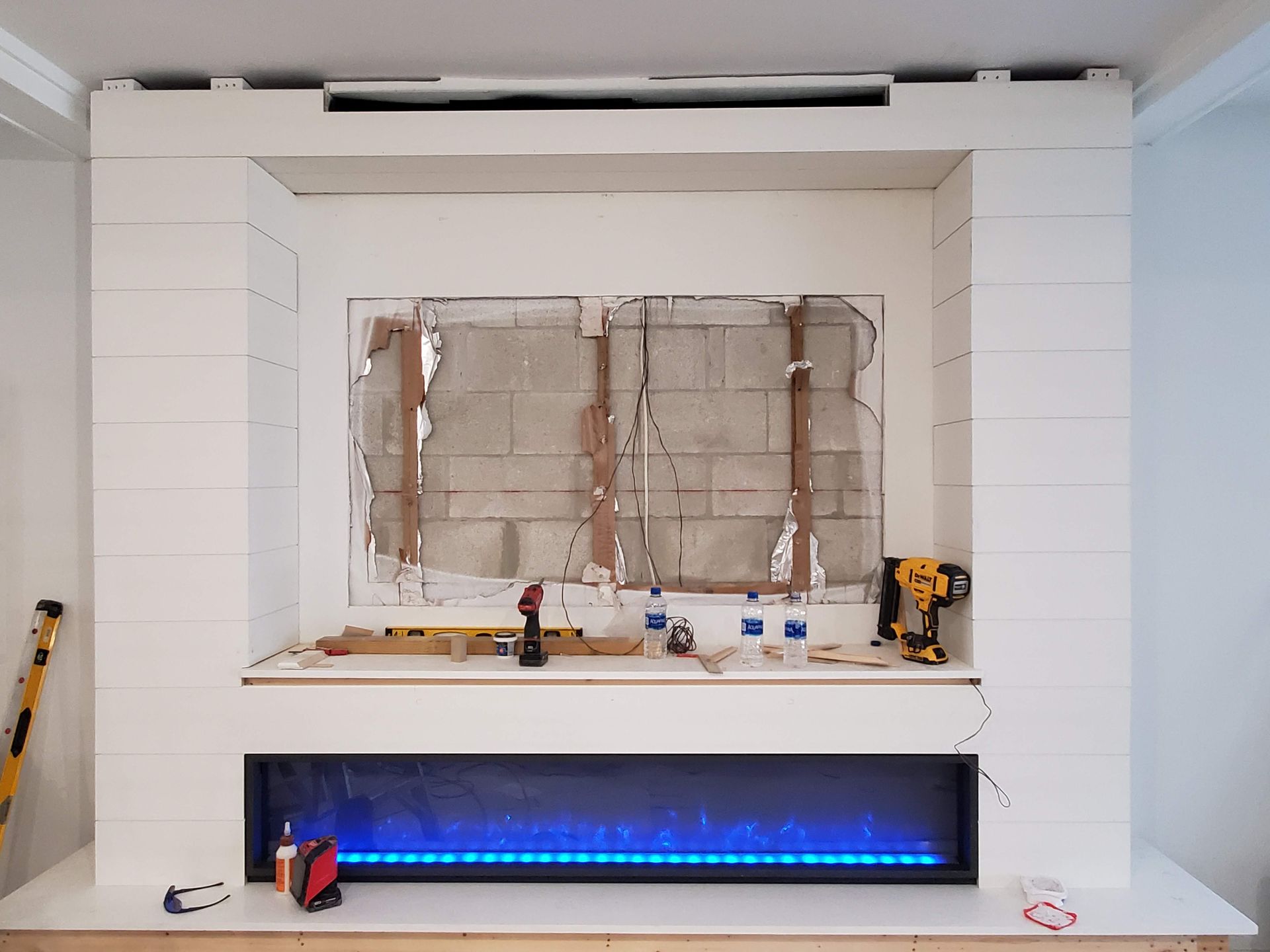 A fireplace is being built in a living room.