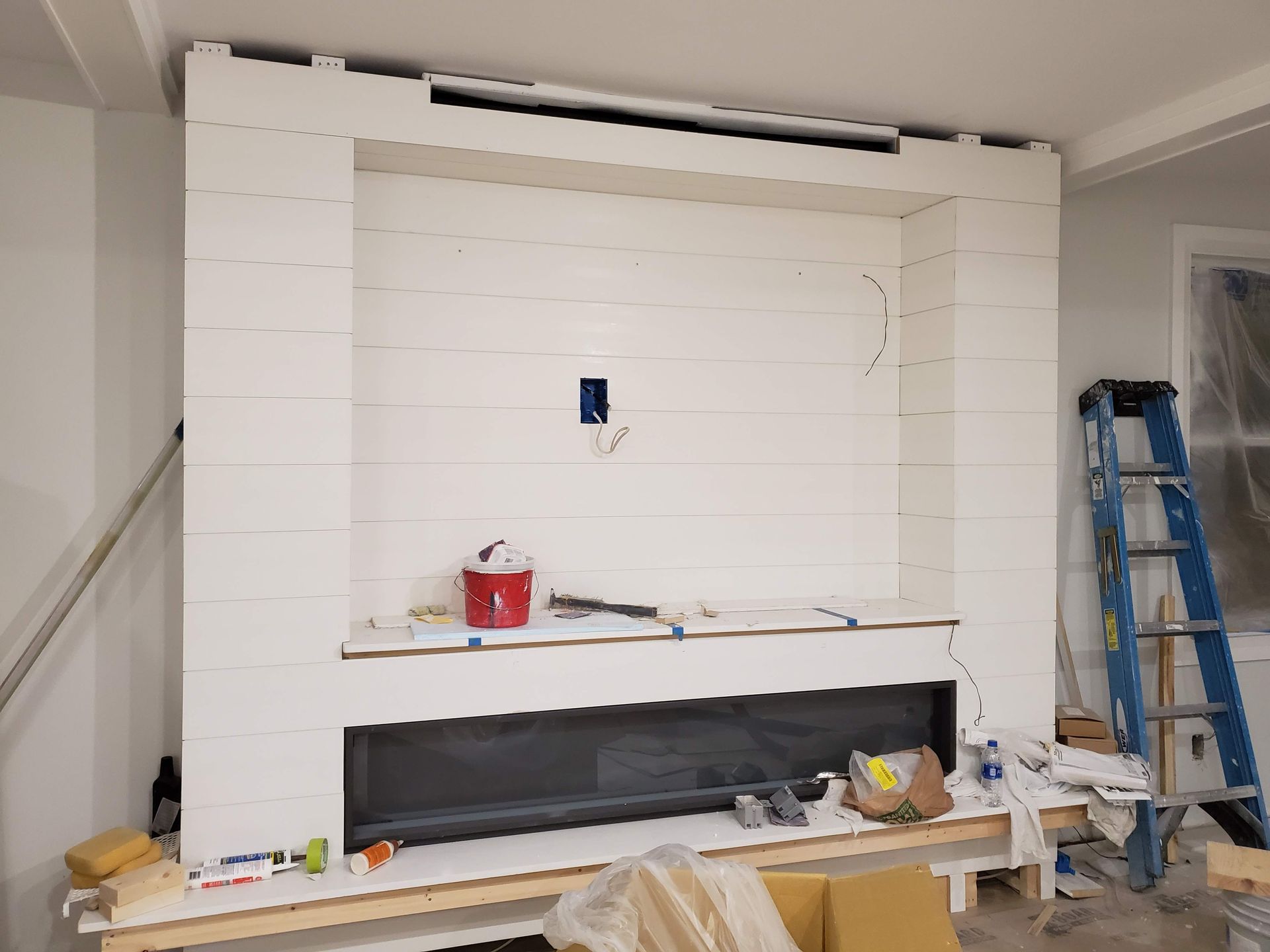 A fireplace is being built in a living room.