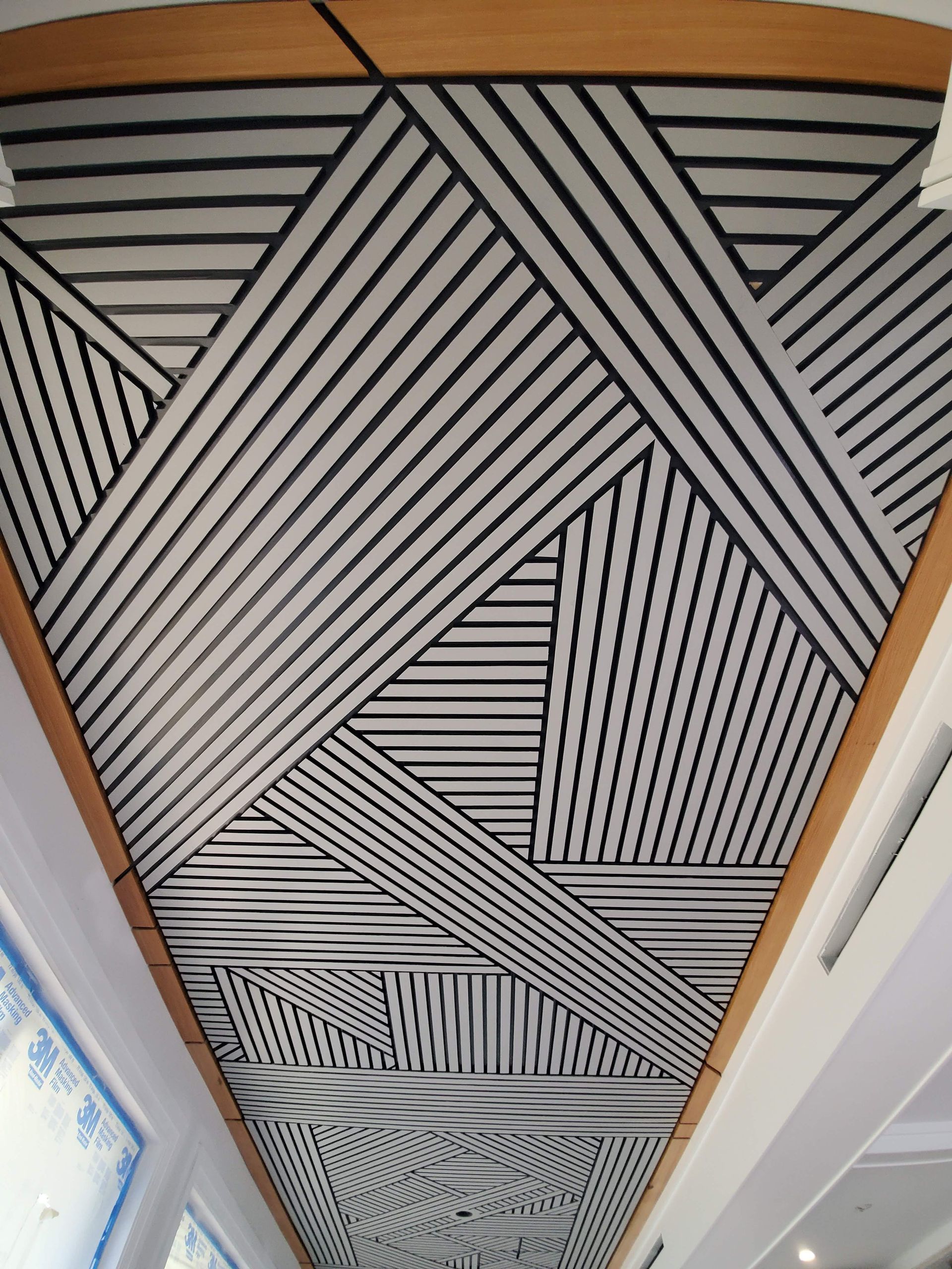 A black and white striped ceiling with a wooden frame