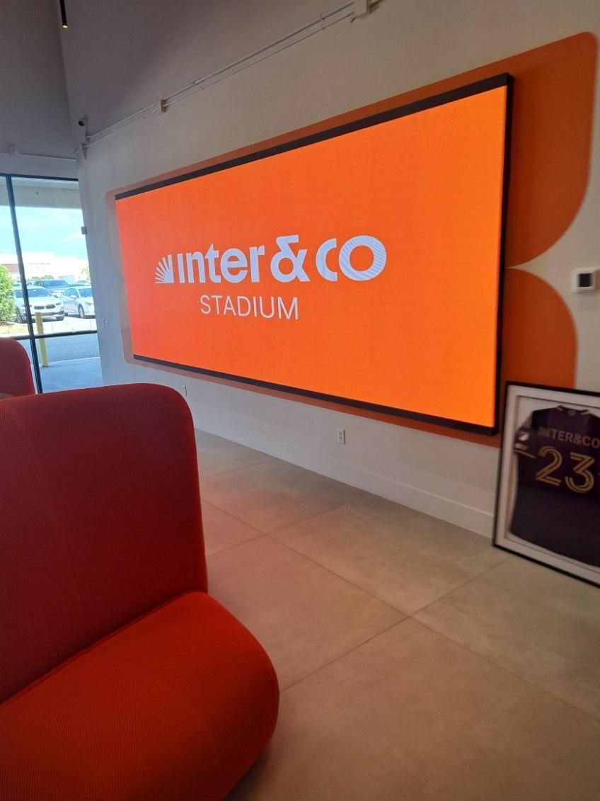 A large screen hanging on a wall that says inter & co stadium