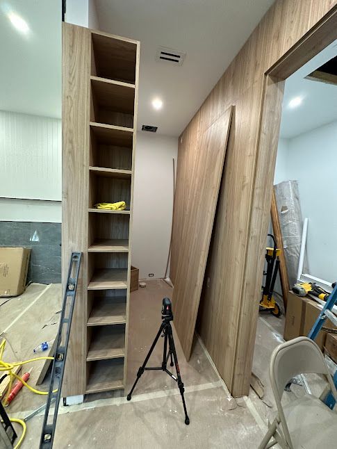 A room with wooden shelves and a ladder in it.