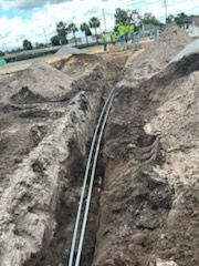 A pipe is being installed in a trench in the dirt.